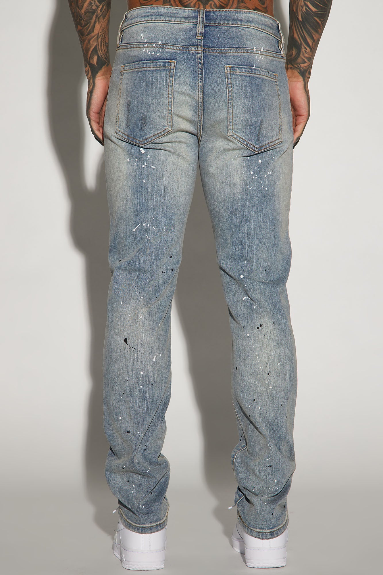 Edgy and Trendy: Ripped and Bleach Splatter Slim Jeans in Light Blue Wash